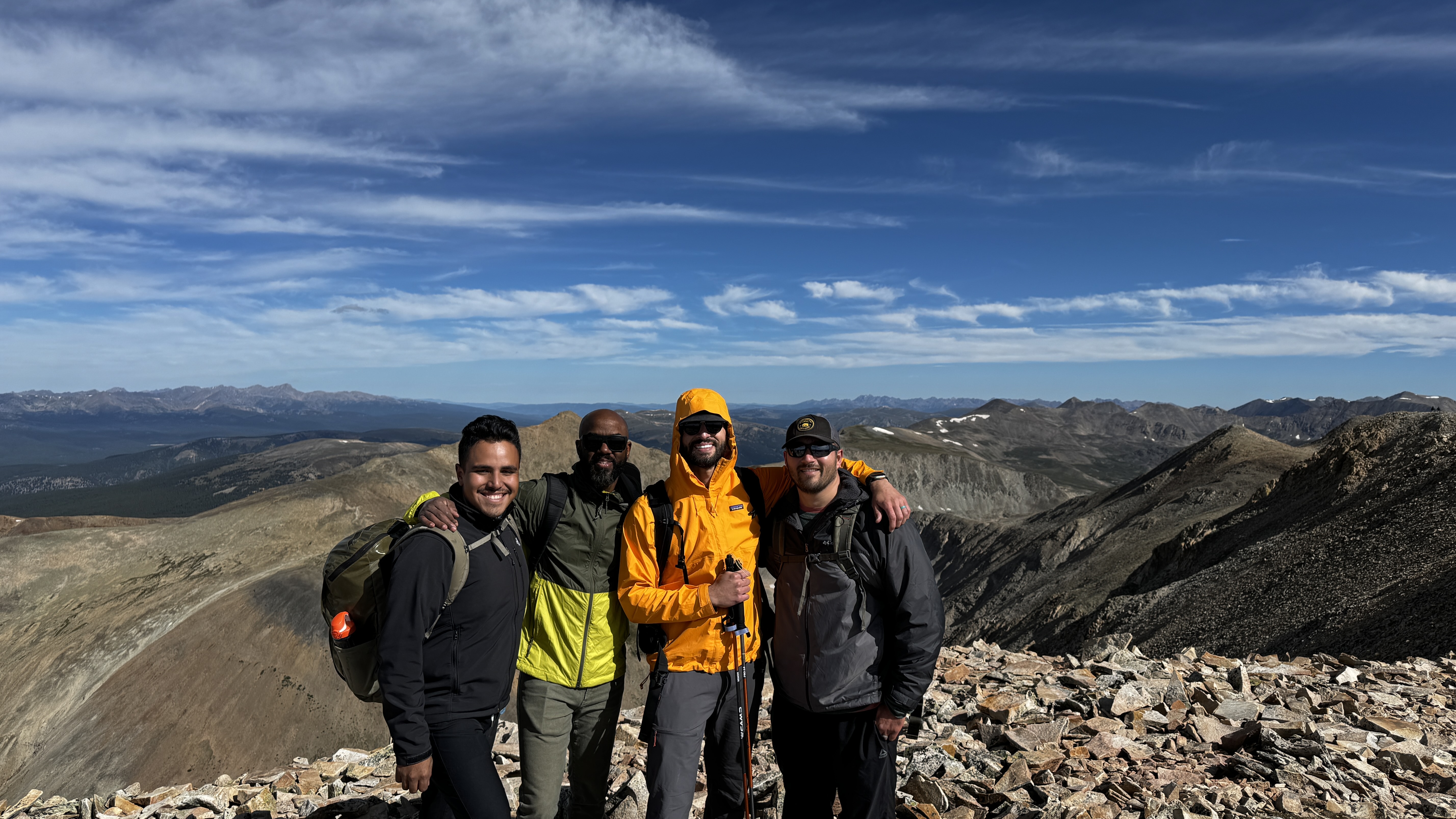Group of friends at a Colorado 14er summit after a hike