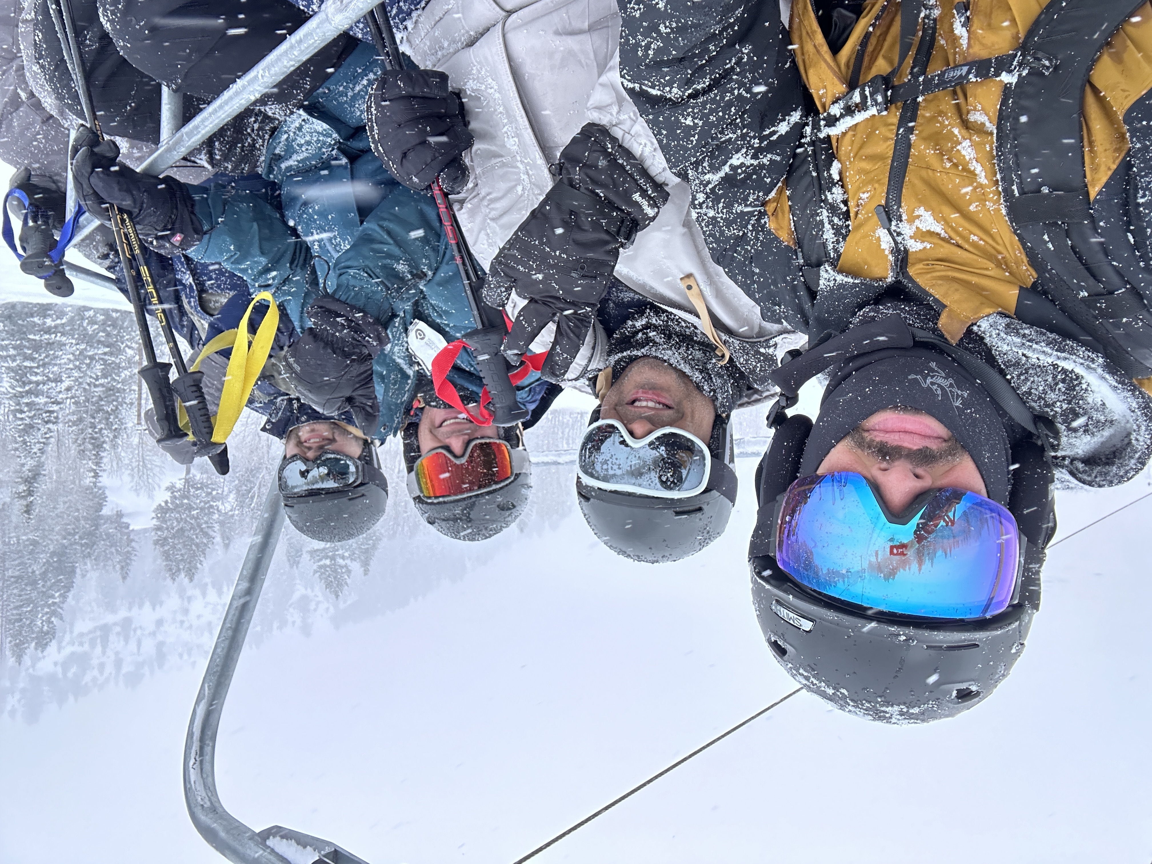 Friends riding a chairlift on a snowy ski day